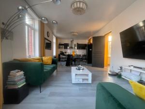 a living room with a green couch and a table at Appartement cosy 6 personnes in Anzin