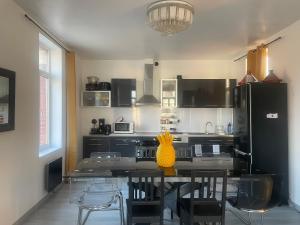 a kitchen with a table with a yellow pineapple on it at Appartement cosy 6 personnes in Anzin