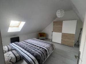 a attic bedroom with a bed and a skylight at Appartement cosy 6 personnes in Anzin
