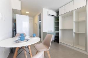 a white dining room with a white table and chairs at Neo Duos #505 - Intermares por Carpediem in Ilha da Restinga