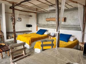 a bedroom with two beds with yellow sheets and blue pillows at Departamentos Maya in Isla Mujeres