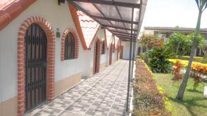 a walkway leading to a building with a black gate at Hotel Las Victorias Palmira in Palmira