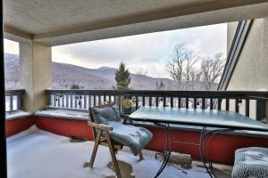 キリングトンにあるMountain Views at Mt Green 2BR-2BA, Shuttle, Discounted Lifts, Pool, Hot Tub and More!のバルコニー(雪の中のテーブルと椅子付)