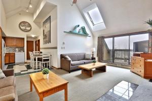 een woonkamer met een bank en een tafel bij Loft, Top-Floor Mountain View 2BR-2BA at Mountain Green, Pool, Hot Tub, Shuttle in Killington