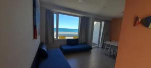 a room with a large window with a view of the ocean at Bahia creek in Las Grutas +1 photo