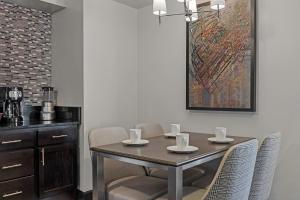 a dining room table with chairs and a painting on the wall at Club Wyndham Canterbury in San Francisco