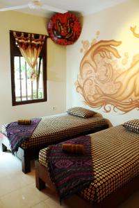 een kamer met 2 bedden en een raam bij Hotel 1001 Malam in Yogyakarta