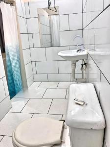 a white bathroom with a toilet and a sink at Miami Studios DR in Santo Domingo +28 photos