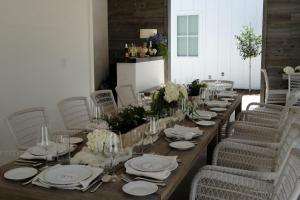 a long table with chairs and plates and wine glasses at Whitetail Court Hotel in Fredericksburg