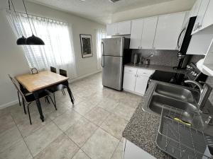a kitchen with a table and a stainless steel refrigerator at Miami's Cozy Tropical Getaway in Miami