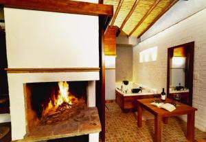 a fireplace in a living room with a table and a table at VoyAca Hotel - Alfareria in Villa de Leyva +71 photos