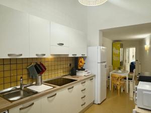 a kitchen with white cabinets and a white refrigerator at Domus Selene Pompei in Pompei