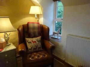 a chair in a room with a lamp and a window at Yr Hen Felin - The Old Mill B&B in Morfa Nefyn