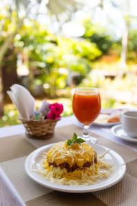 a plate of food on a table with a drink at Pousada Lenda das Águas in Fernando de Noronha