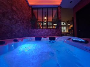 jacuzzi con iluminación azul en una habitación en Ospaloft, meublé haut de gamme avec spa privatif, en Arras