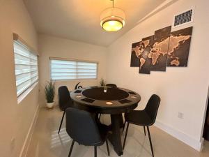 マイアミにあるModern Home w Jacuzzi Near Wynwood-Design District-MIA Airportの黒いテーブルと椅子のあるダイニングルーム