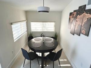 マイアミにあるModern Home w Jacuzzi Near Wynwood-Design District-MIA Airportの黒いテーブルと椅子のあるダイニングルーム