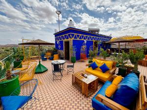 a patio with a blue and yellow couch and chairs at Riad Chay & Boutique in Ouarzazate
