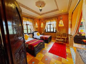 a bedroom with two beds and a couch in it at Riad Chay & Boutique in Ouarzazate