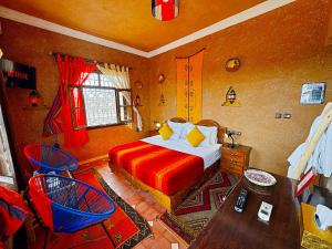 a bedroom with a bed and a table in it at Riad Chay & Boutique in Ouarzazate