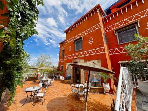 a patio with tables and chairs in front of a building at Riad Chay & Boutique in Ouarzazate
