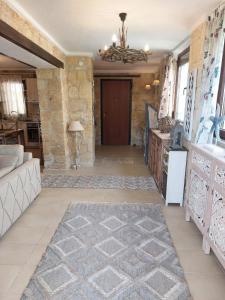 a living room with a stone wall and a chandelier at STONE Villa in Siviri +26 photos