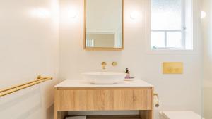 a bathroom with a white sink and a mirror at Welcome To Queenslander By The Sea in South Golden Beach +14 photos