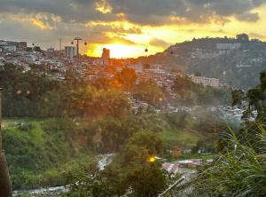 a view of a city with the sun setting in the background at Excelente ubicación como en casa tranquilidad in Villamaría