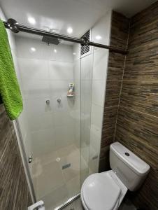 a bathroom with a toilet and a glass shower at Excelente ubicación como en casa tranquilidad in Villamaría