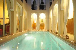 a large swimming pool in a large building at Riad Nafis in Marrakech