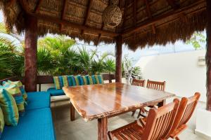 une salle à manger avec une table et des chaises en bois dans l'établissement Beautiful Penthouse with Private Rooftop and Hot Tub, à Tulum