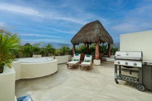 une cuisine extérieure avec une baignoire et un grill dans l'établissement Beautiful Penthouse with Private Rooftop and Hot Tub, à Tulum