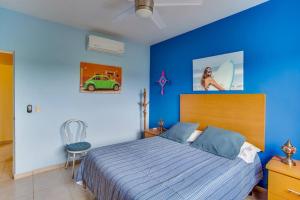 a bedroom with a bed and a blue wall at 2 BR Condo with pool only 15 min to Marina & Beach in Palmar +28 photos