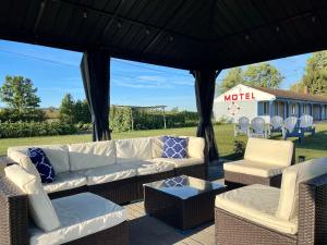 a patio with couches and chairs under a gazebo at Best Motel Bowling Green in Bowling Green