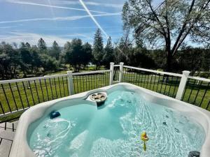 a jacuzzi tub in a yard with a fence at Pinkies Place-Hot Tub-Sleeps 11-Pet Friendly in Ahwahnee