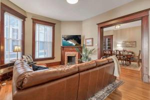 a leather couch in a living room with a fireplace at 4 Bed Duplex near Goodale Park in Columbus