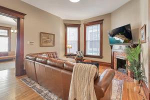 a living room with a leather couch and a fireplace at 4 Bed Duplex near Goodale Park in Columbus