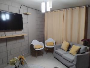 ein Wohnzimmer mit einem Sofa und zwei Sesseln und einem Fernseher in der Unterkunft Casa alojamiento Ordoñez in Ilo