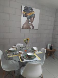 ein Esstisch mit Tellern und Gläsern und einem Bild in der Unterkunft Casa alojamiento Ordoñez in Ilo