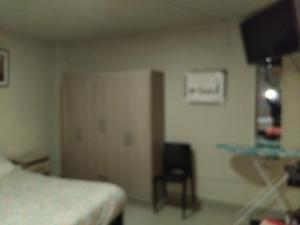 ein Krankenhauszimmer mit einem Bett und einem Stuhl in der Unterkunft Casa alojamiento Ordoñez in Ilo