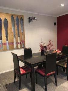 a dining room with a table and chairs and a painting at Lye Bow Lake Suite in Alexandra