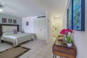 プエルト・バジャルタにあるCasa Vista Hermosa - Beautiful Beach front condoのベッドと花が飾られたテーブルのある寝室 +31枚の写真