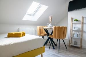 une chambre avec un lit, une table et des chaises dans l'établissement Everman Anzin, à Anzin