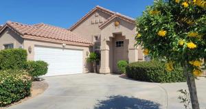 a brown house with a white garage at Sunnyside Up on Arroyo in Indio