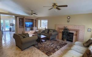 a living room with couches and a fireplace at Sunnyside Up on Arroyo in Indio