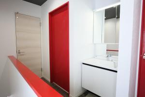a bathroom with a red door and a sink at TR Niseko House Room Sky in Niseko