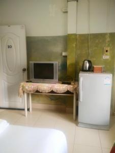 a room with a table with a computer and a refrigerator at Baan Chomchan - Thale Noi บ้านพักชมจันทร์ in Ban Khuan Phanang Tung (1)