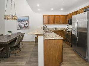 Una cocina con gabinetes de madera y un refrigerador de acero inoxidable. en Aspenwood 311 condo, en Edwards 23 fotos más