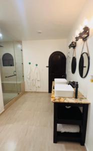 ein Badezimmer mit einer Theke mit einem Waschbecken und einer Dusche in der Unterkunft Casa Castillo Playa in Playa del Carmen + 1 Foto