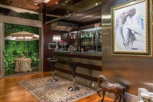 a bar with two stools and a painting on the wall at Mini Palace Hotel in Viterbo